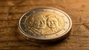 Moneta da 2 euro del Lussemburgo 2009 con due volti in rilievo su sfondo in legno