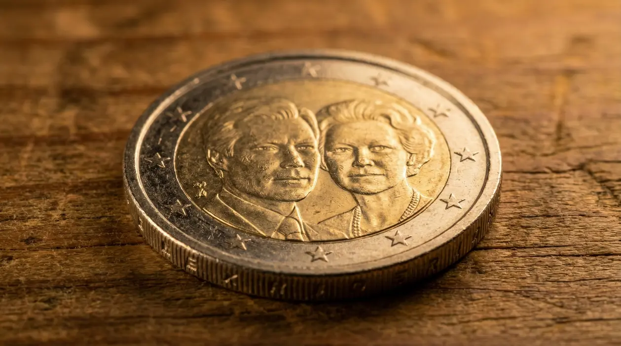 Moneta da 2 euro del Lussemburgo 2009 con due volti in rilievo su sfondo in legno