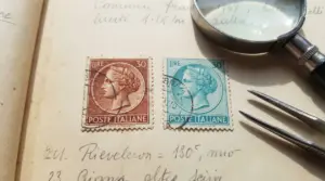 Due francobolli da 30 lire della serie Siracusana, uno marrone e uno azzurro, su sfondo con lente e pinzetta