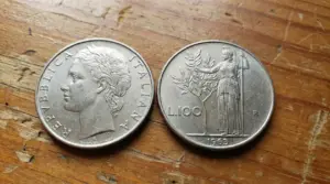 Due monete da 100 lire italiane del 1963 su una superficie in legno
