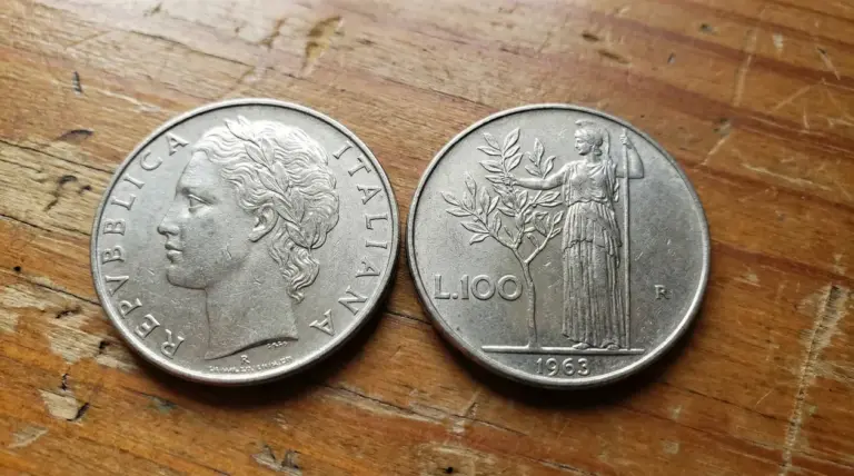Due monete da 100 lire italiane del 1963 su una superficie in legno