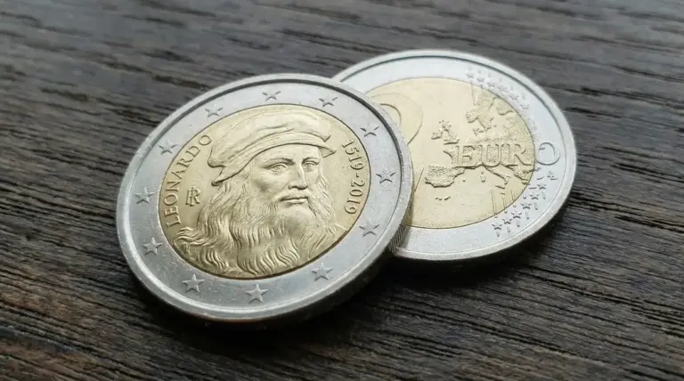 Moneta da 2 euro commemorativa con il volto di Leonardo Da Vinci su sfondo di legno