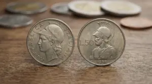 Due monete italiane da 50 lire con elmetto su un tavolo di legno