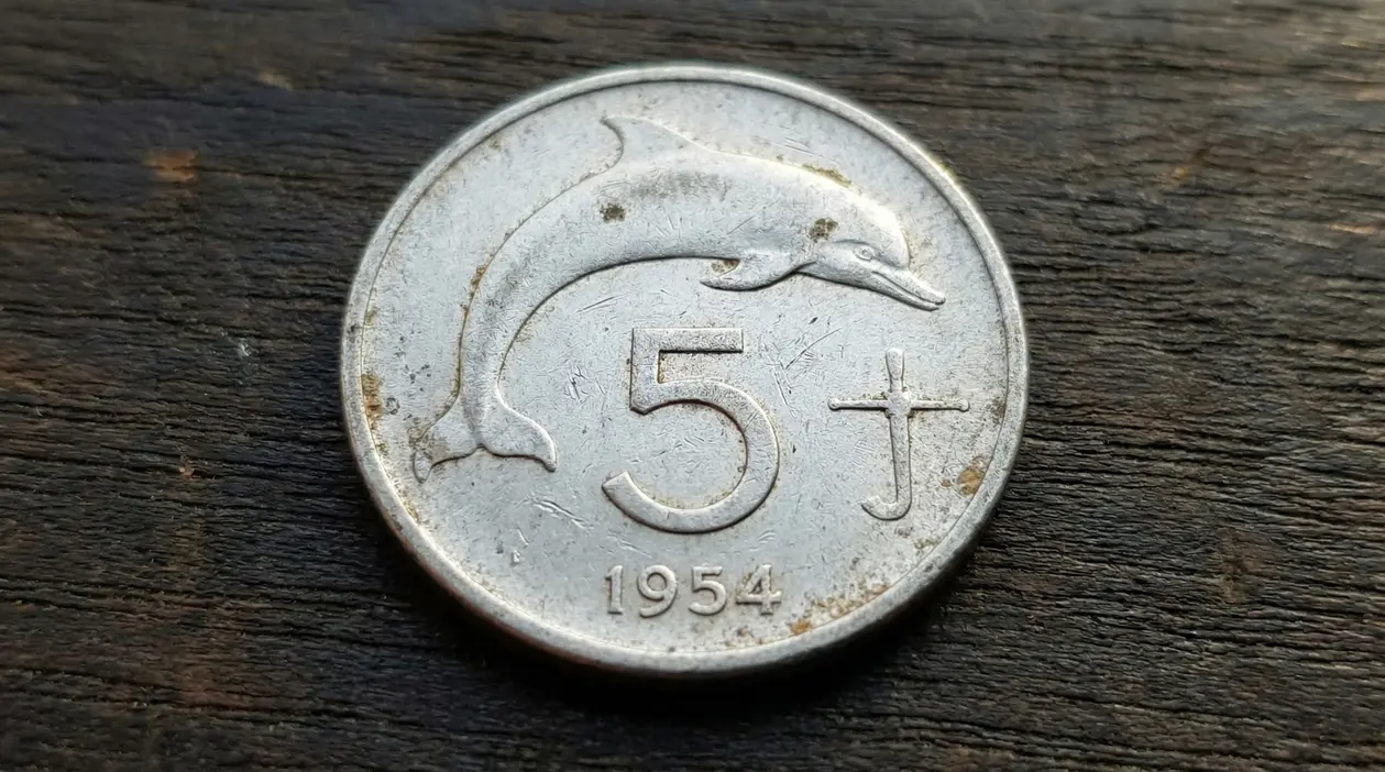 Vecchia moneta italiana da 5 lire del 1954 con un delfino inciso su un lato