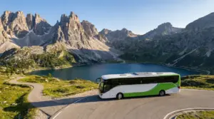 Autobus su strada panoramica tra le montagne delle Dolomiti vicino a un lago alpino